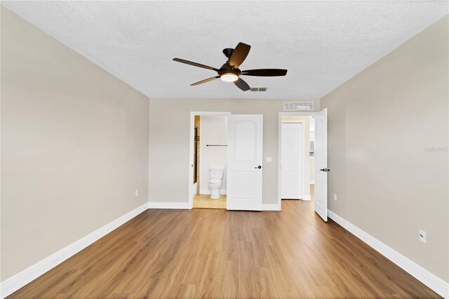 unfurnished bedroom featuring wood finished floors, visible vents, and baseboards