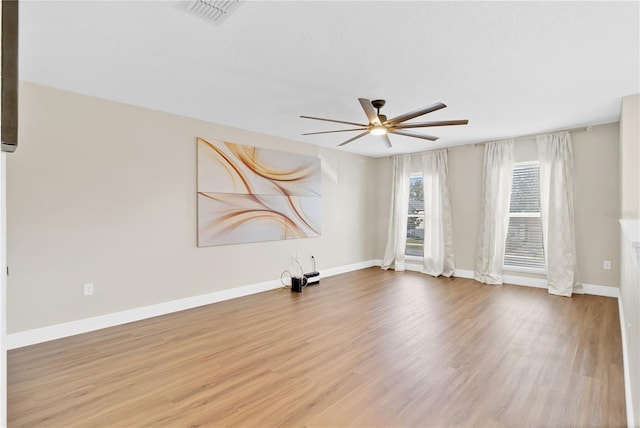 empty room with visible vents, ceiling fan, baseboards, and wood finished floors