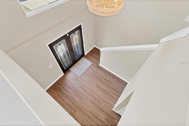 foyer with baseboards, wood finished floors, and french doors