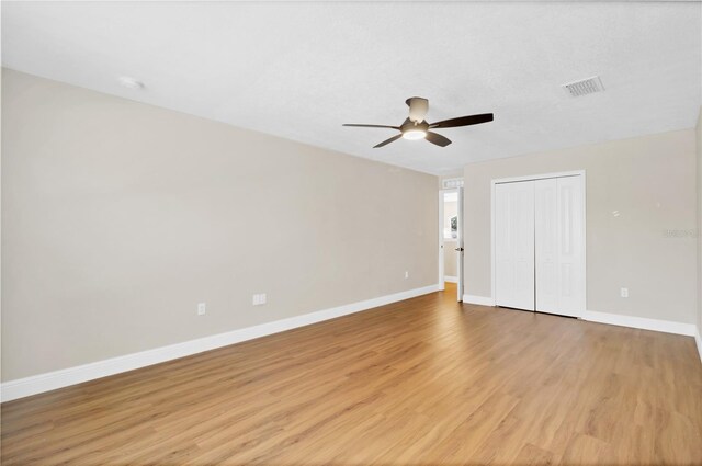 unfurnished bedroom featuring a closet, visible vents, light wood-style flooring, and baseboards