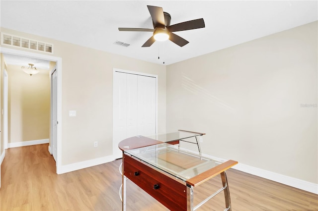 office with light wood-type flooring, visible vents, and baseboards