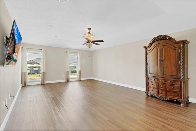 unfurnished room with baseboards, a ceiling fan, and light wood-style floors