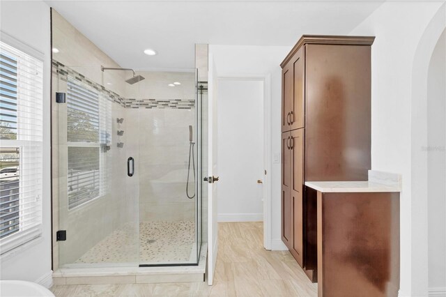 bathroom featuring a shower stall, baseboards, and recessed lighting