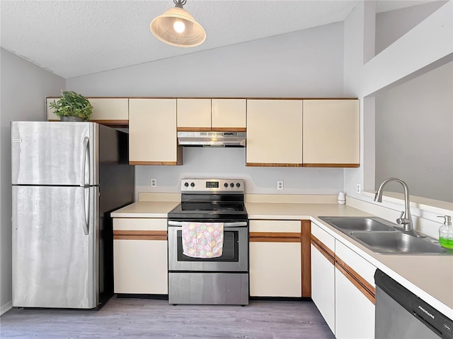 kitchen featuring vaulted ceiling, appliances with stainless steel finishes, a sink, and under cabinet range hood