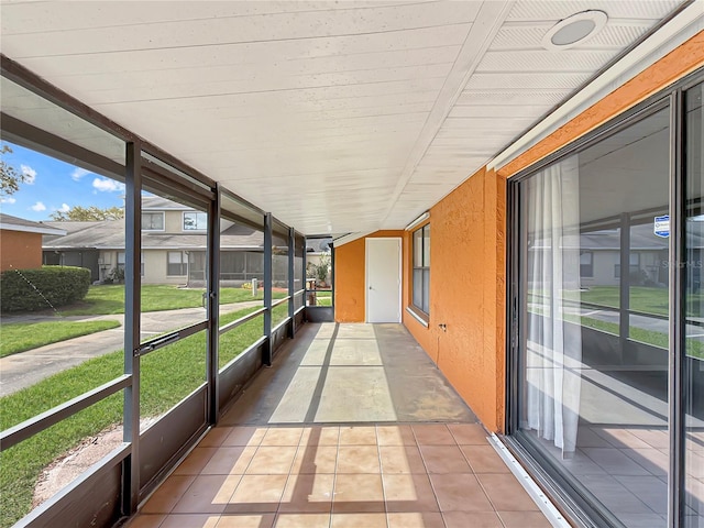 unfurnished sunroom with a residential view and a wealth of natural light