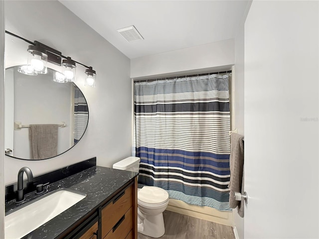 full bath with visible vents, vanity, toilet, and wood finished floors