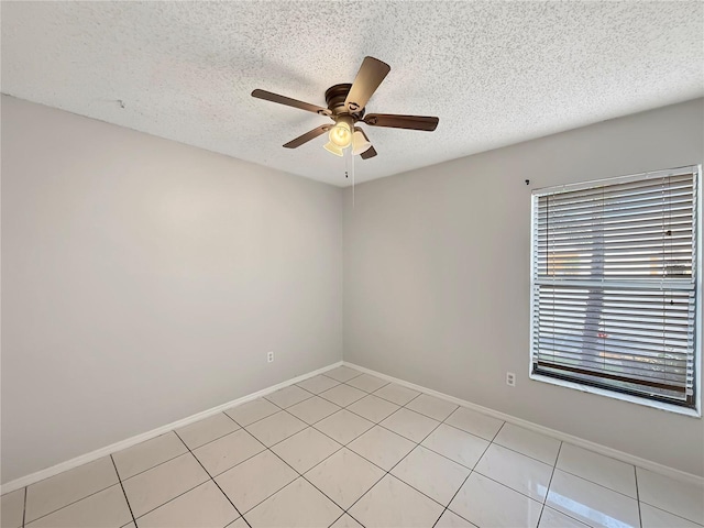 unfurnished room featuring a textured ceiling, a ceiling fan, and baseboards