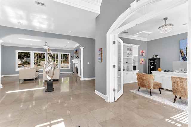 entrance foyer with baseboards, arched walkways, and ornamental molding