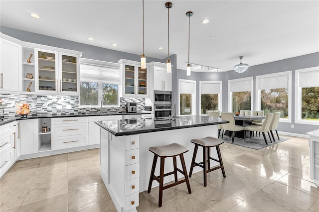 kitchen with stainless steel appliances, tasteful backsplash, open shelves, and white cabinets