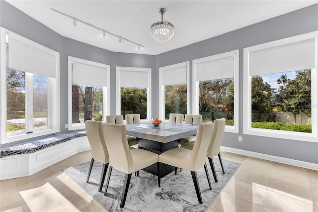 sunroom / solarium featuring a chandelier