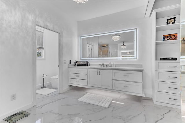 full bath featuring toilet, marble finish floor, baseboards, and vanity