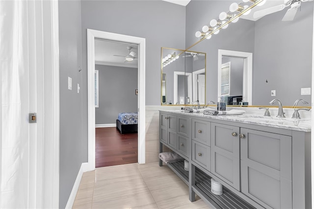 full bath featuring double vanity, a ceiling fan, ensuite bath, crown molding, and a sink