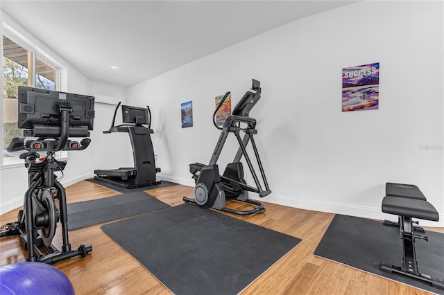 exercise room featuring recessed lighting, wood finished floors, and baseboards