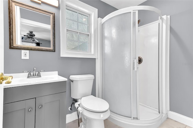 full bathroom with toilet, a stall shower, vanity, and baseboards