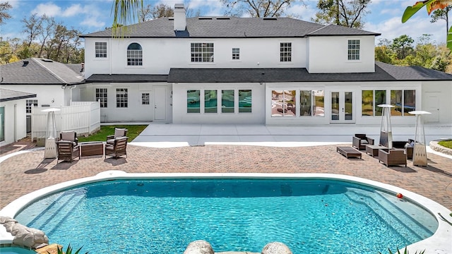 rear view of house with a patio, stucco siding, an outdoor living space, and an outdoor pool