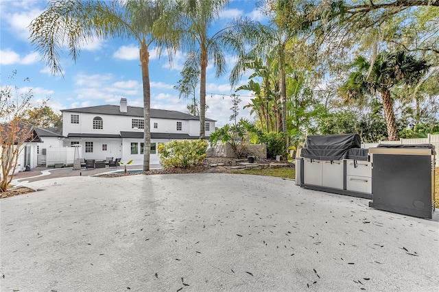 rear view of property with a patio area and fence