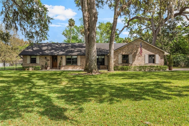 view of front facade with fence, a front lawn, and brick siding