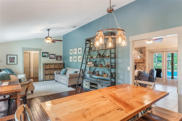 dining area featuring lofted ceiling, wood finished floors, a ceiling fan, and french doors