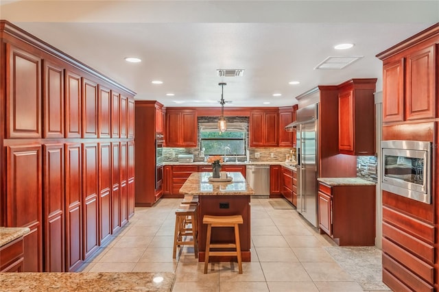 kitchen featuring built in appliances, dark brown cabinets, light tile patterned floors, and visible vents