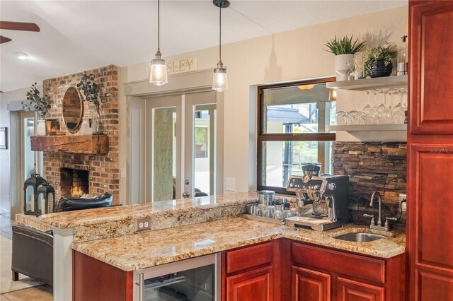 kitchen featuring wine cooler, light stone countertops, a brick fireplace, open shelves, and a sink