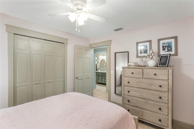 bedroom featuring a textured ceiling, ceiling fan, visible vents, baseboards, and a closet