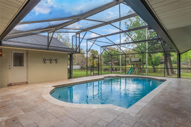 outdoor pool featuring glass enclosure, a patio area, and a playground