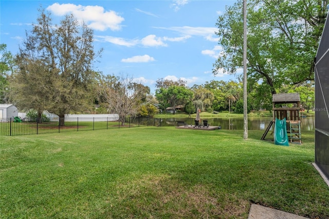 view of yard featuring a playground, fence, and a water view