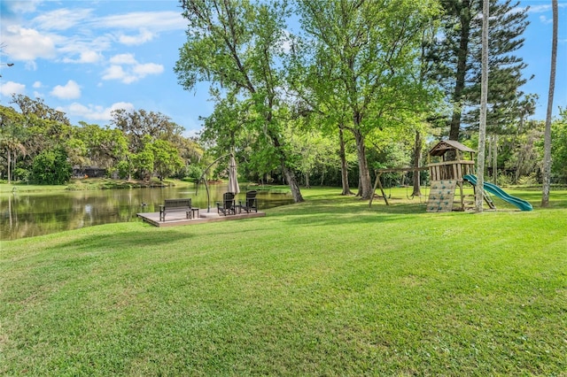 view of yard featuring playground community and a water view