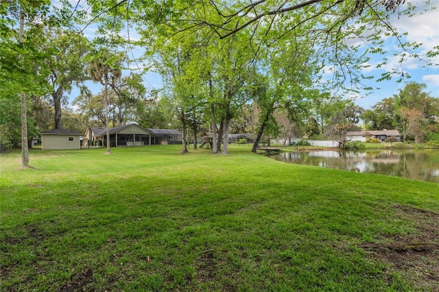 view of yard with a water view and a sunroom