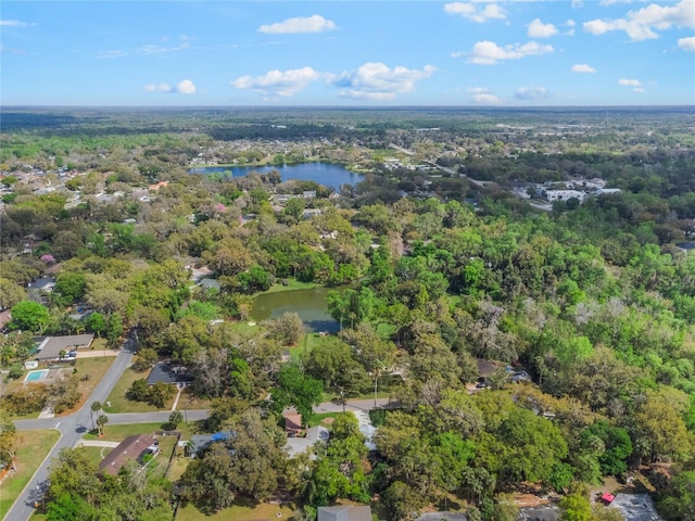 drone / aerial view featuring a water view and a wooded view