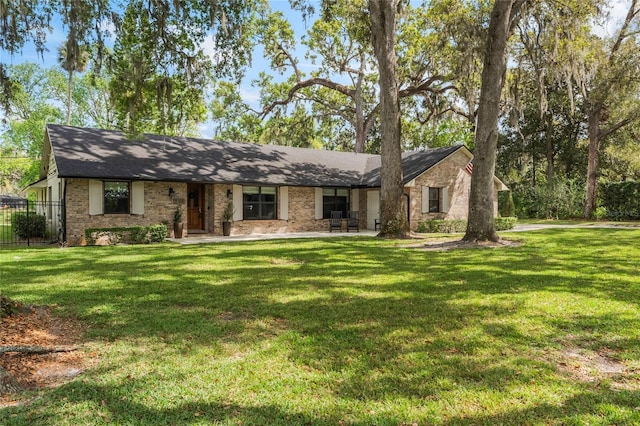 view of front facade with a front yard and brick siding