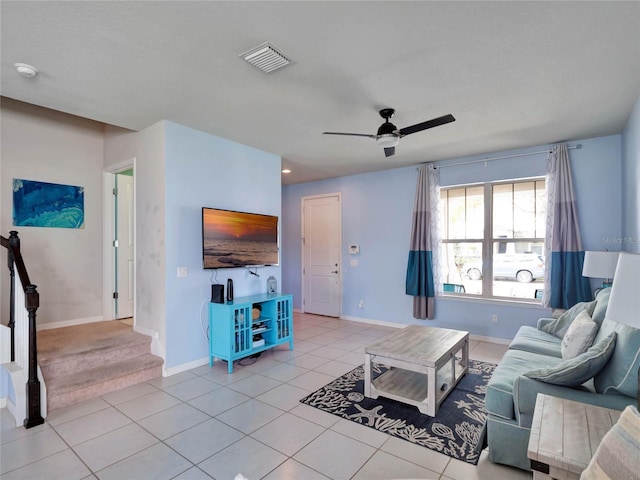 living room featuring visible vents, baseboards, ceiling fan, stairway, and light tile patterned flooring