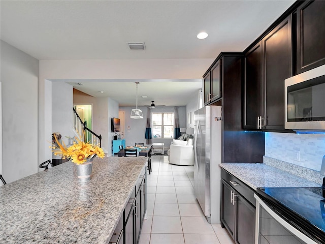 kitchen featuring light tile patterned flooring, visible vents, open floor plan, appliances with stainless steel finishes, and tasteful backsplash