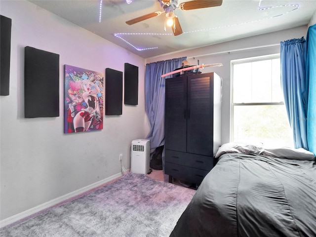 carpeted bedroom with a ceiling fan and baseboards