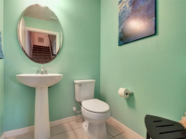 half bathroom with toilet, visible vents, baseboards, and tile patterned floors