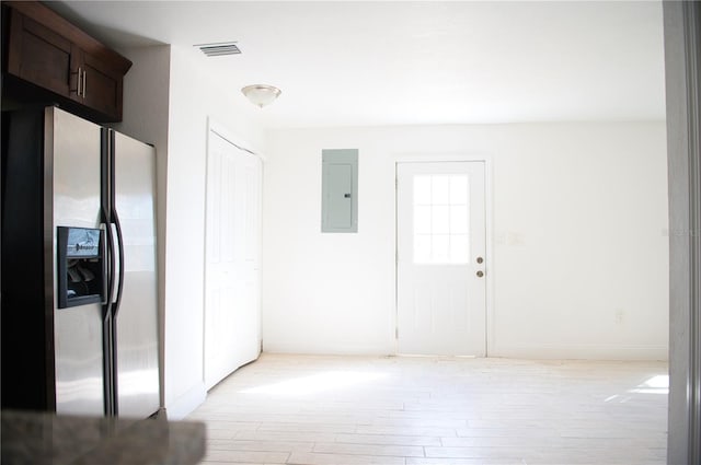 hall with light wood-style floors, visible vents, electric panel, and baseboards