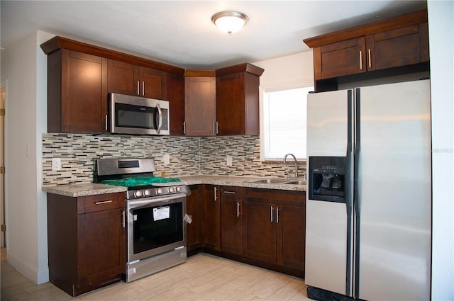 kitchen with light countertops, appliances with stainless steel finishes, backsplash, and a sink