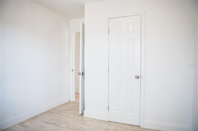 unfurnished bedroom with light wood-type flooring and baseboards