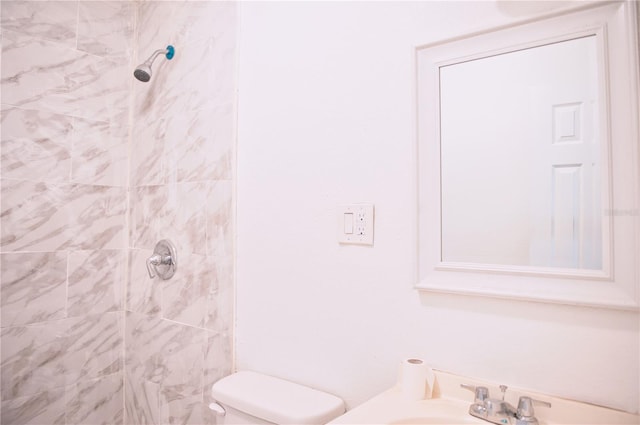 full bathroom featuring toilet, tiled shower, and vanity