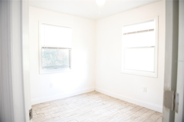 unfurnished room with light wood-style flooring and baseboards