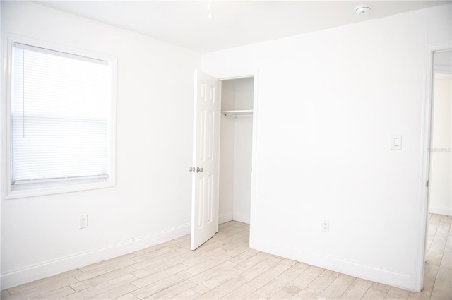 unfurnished bedroom featuring light wood-style flooring and baseboards