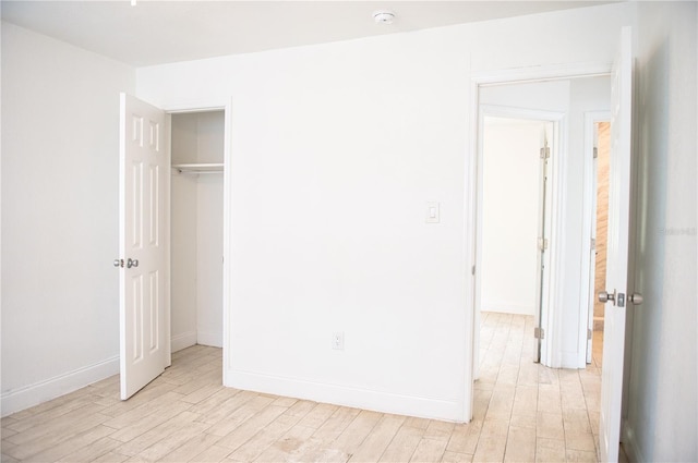 unfurnished bedroom with light wood-type flooring and baseboards