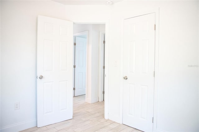 unfurnished bedroom featuring light wood-style flooring and baseboards