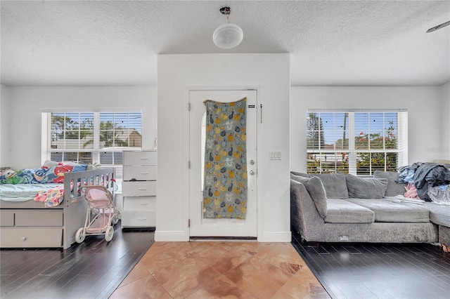 entrance foyer featuring a wealth of natural light, a textured ceiling, and baseboards