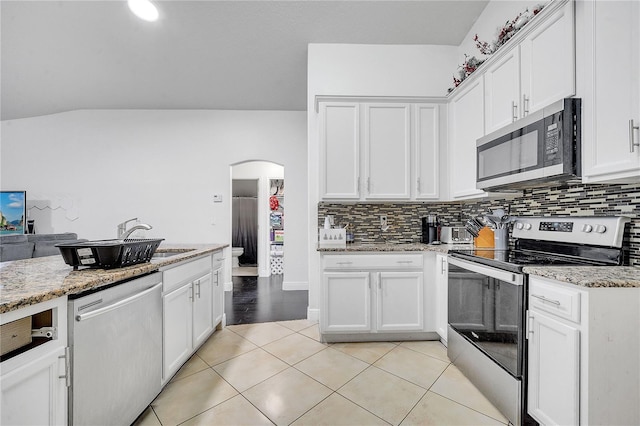 639 Mesilla Dr, Kissimmee, FL 34758 - kitchen with arched walkways, appliances with stainless steel finishes, white cabinetry, and a sink