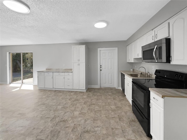 kitchen featuring black appliances, a sink, light countertops, and white cabinets