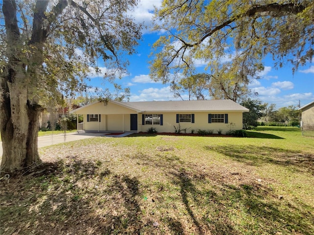 view of front of house featuring an attached carport, concrete driveway, and a front yard