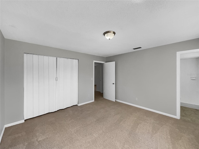 unfurnished bedroom with carpet, baseboards, visible vents, and a closet