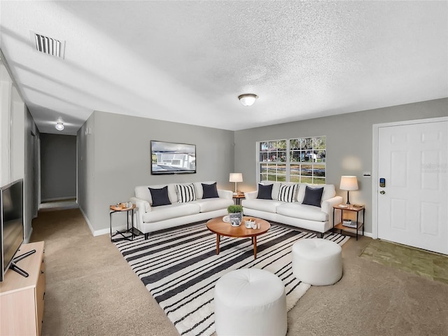 living area featuring baseboards, a textured ceiling, visible vents, and carpet flooring