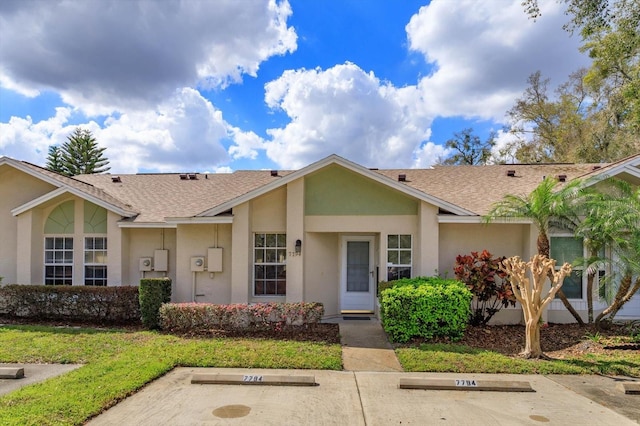 ranch-style home featuring uncovered parking, roof with shingles, and stucco siding